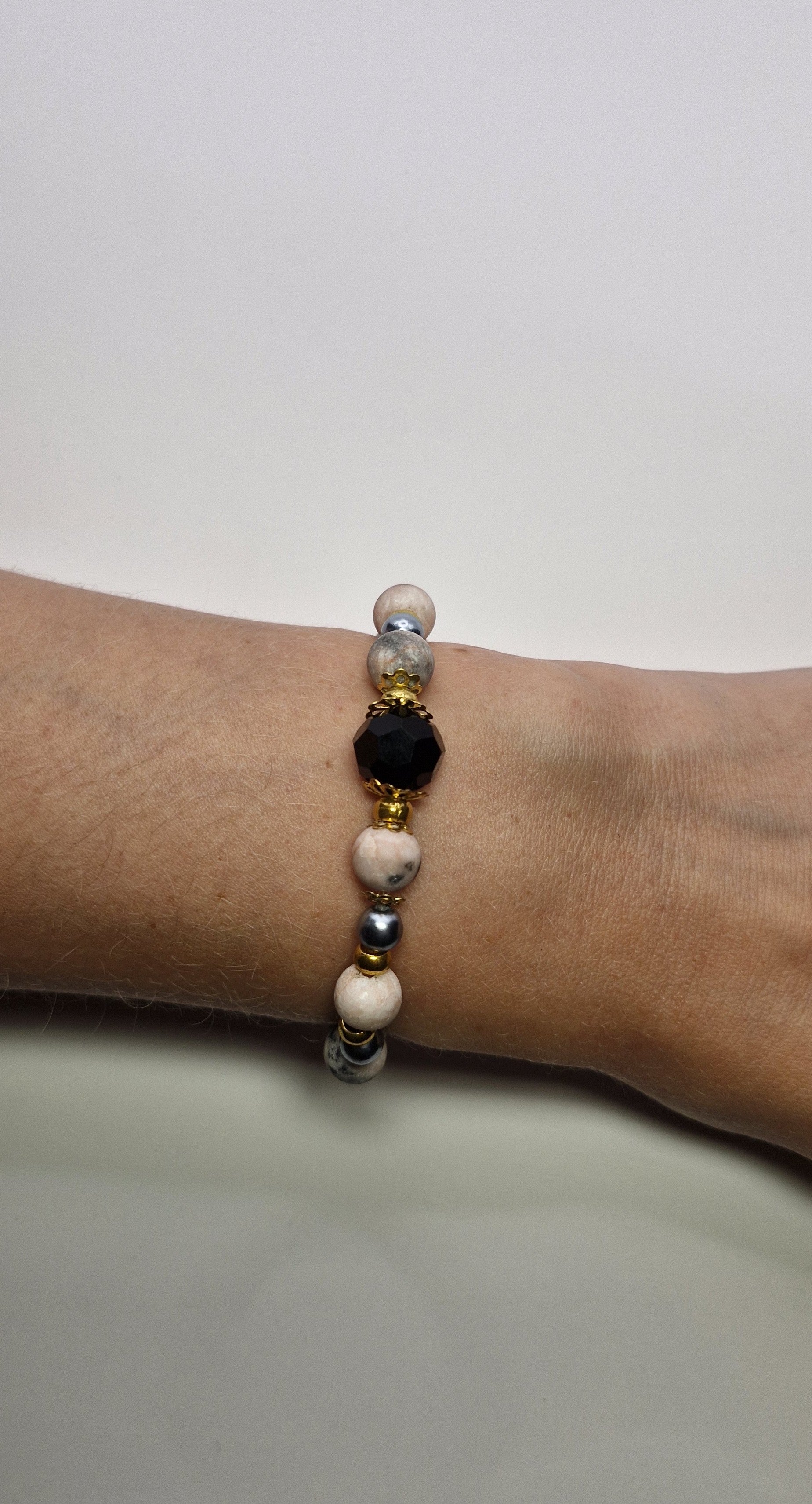 Bransoletka z czarną fasetowaną kulą i złotymi akcentami