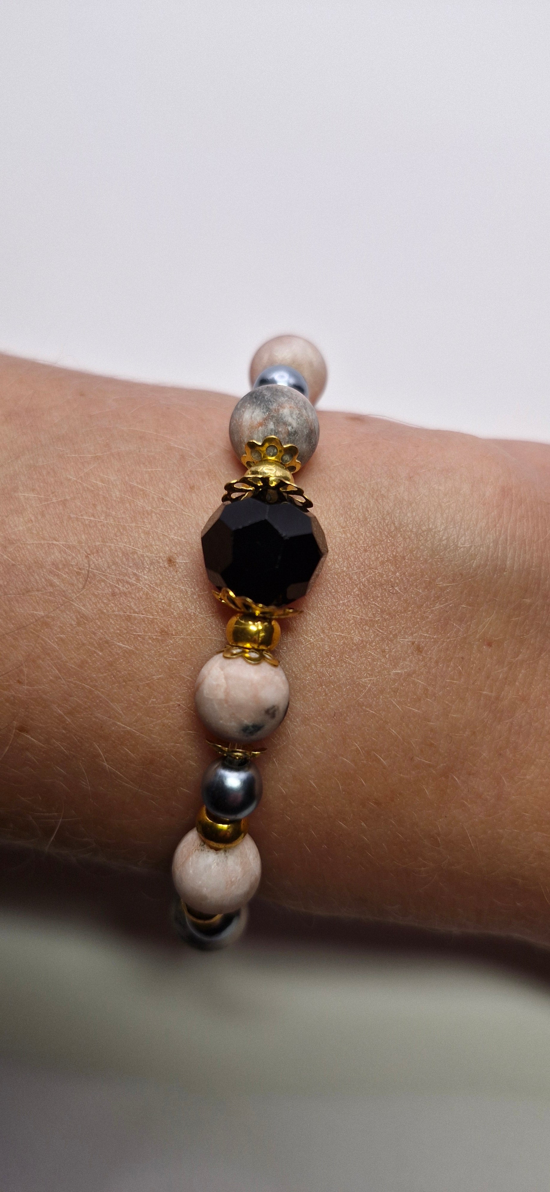 Bransoletka z czarną fasetowaną kulą i złotymi akcentami