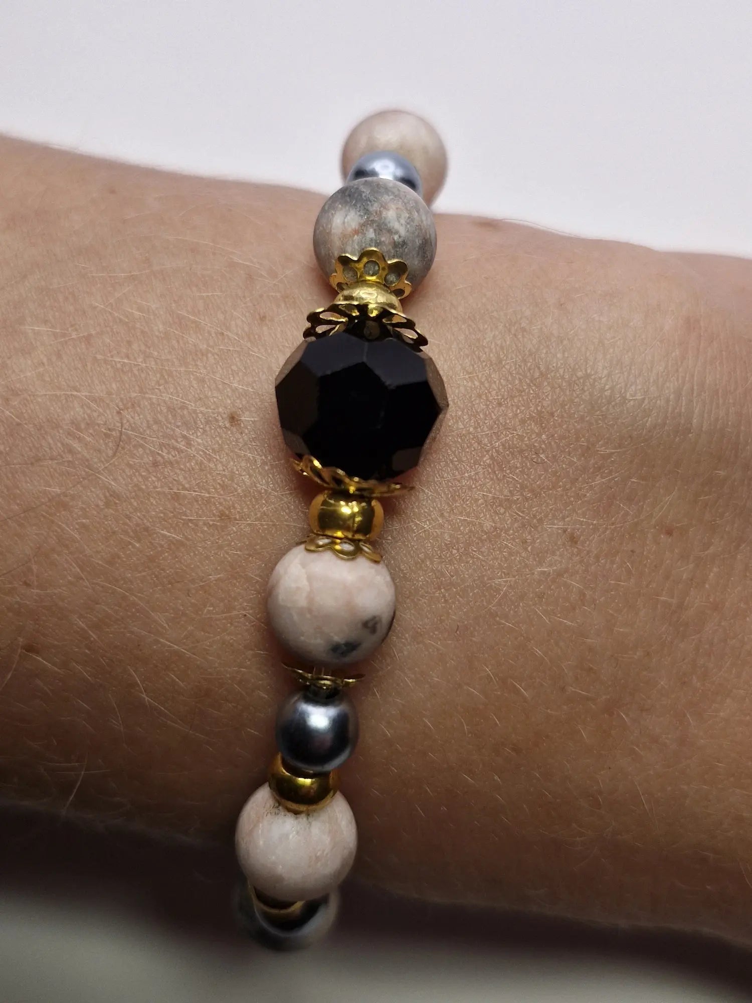 Bransoletka z czarną fasetowaną kulą i złotymi akcentami